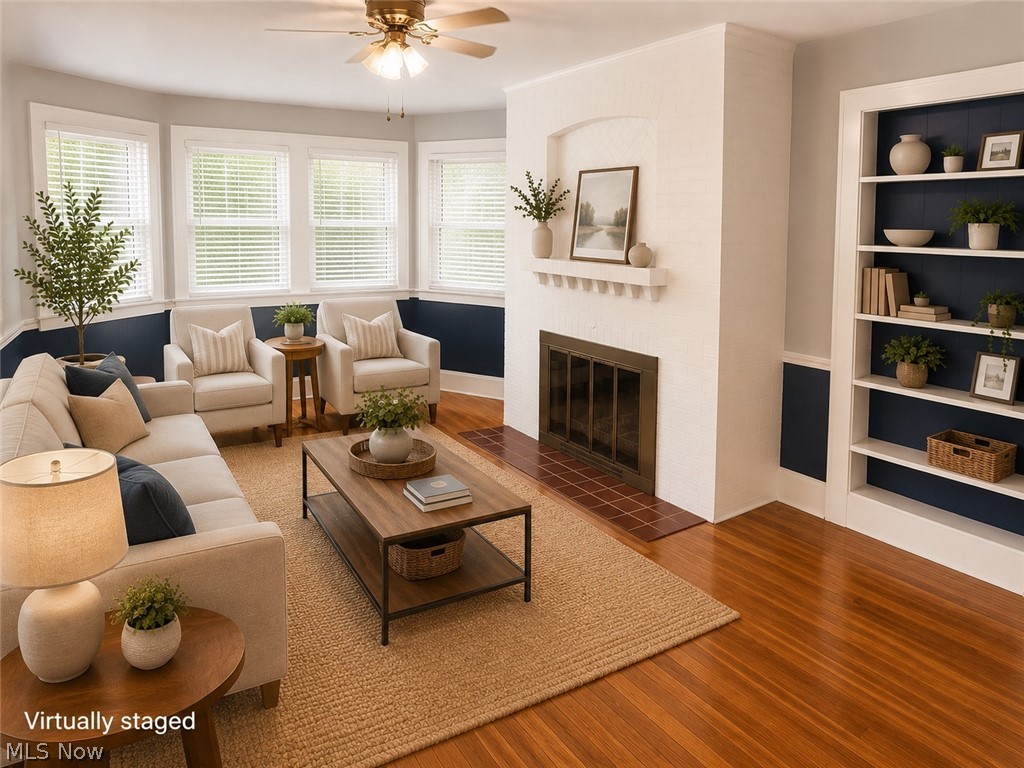 7121 North Lima Road Youngstown, OH 44514 - Photo 7 of 37 Living space featuring wood-finish flooring and a white brick fireplace with a tile hearth