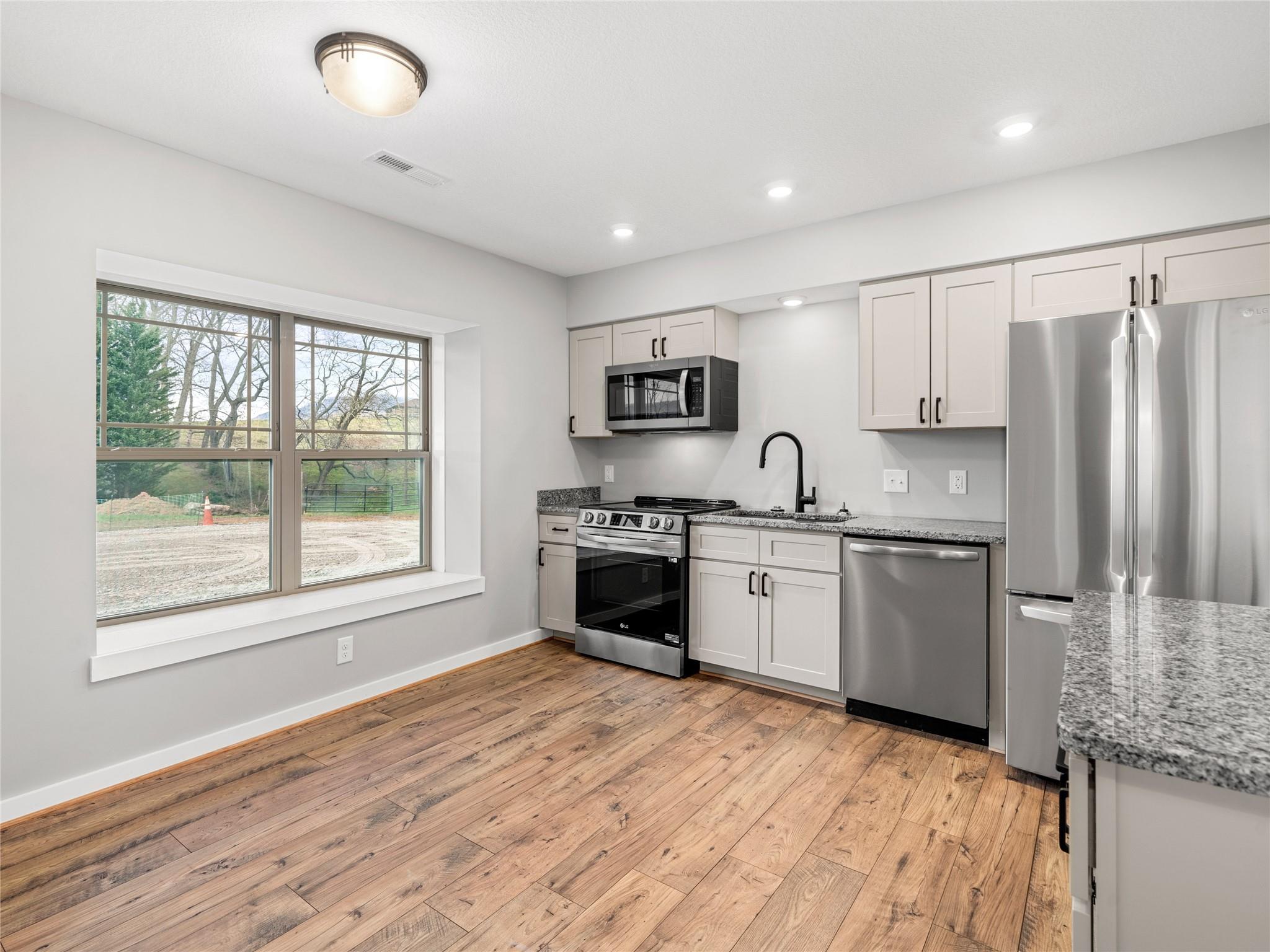 56 Trevor Trail Clyde, NC 28721 - Photo 3 of 27 a kitchen with granite countertop a refrigerator stove and sink