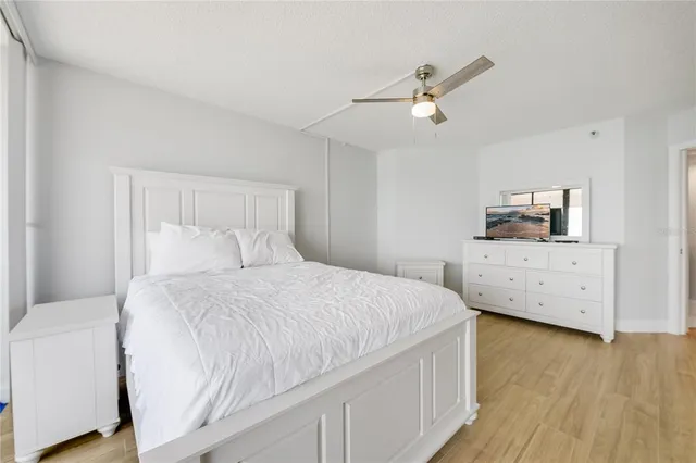 a bed room with a bed and a ceiling fan