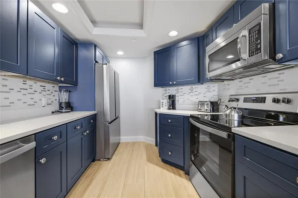 a kitchen with stainless steel appliances granite countertop a sink refrigerator stove and microwave