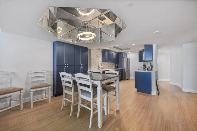 a view of a dining room with furniture a kitchen and chandelier