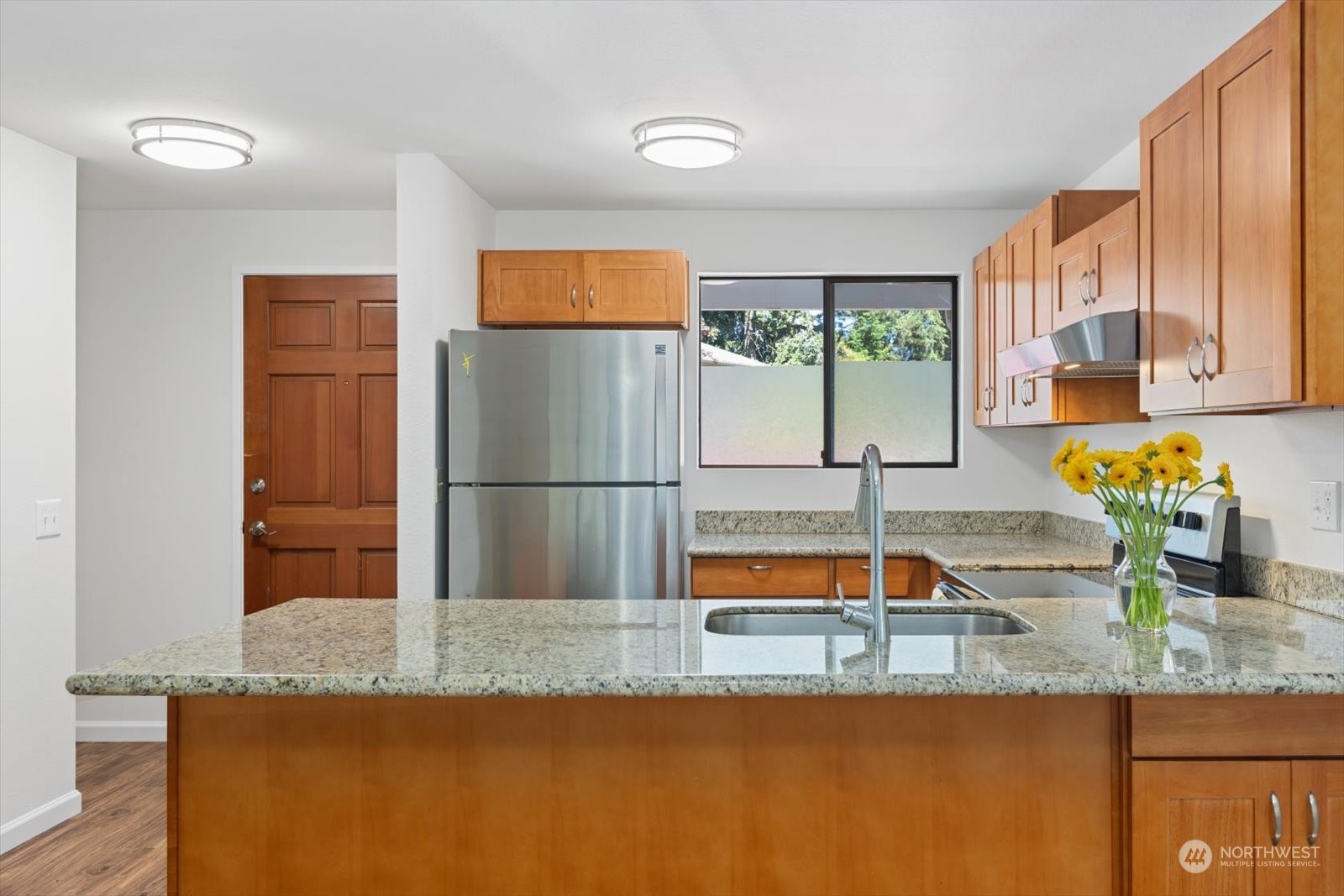 22906 Edmonds Way, Unit 9 Edmonds, WA 98020 - Photo 5 of 22 a kitchen with granite countertop a refrigerator a sink and a counter top space