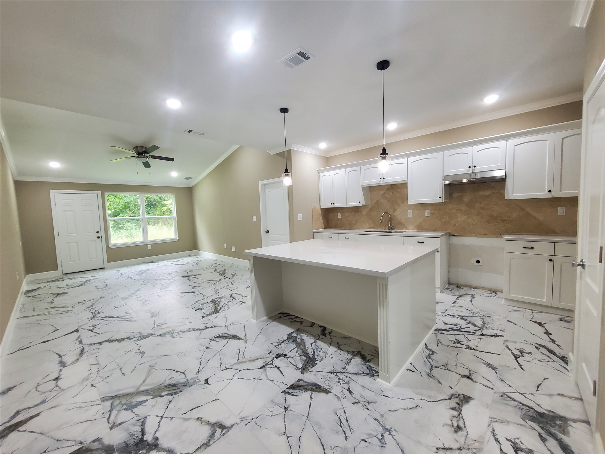 1306 North 9th Street Conroe, TX 77301 - Photo 26 of 47 a large room with kitchen island a sink a counter space and a window