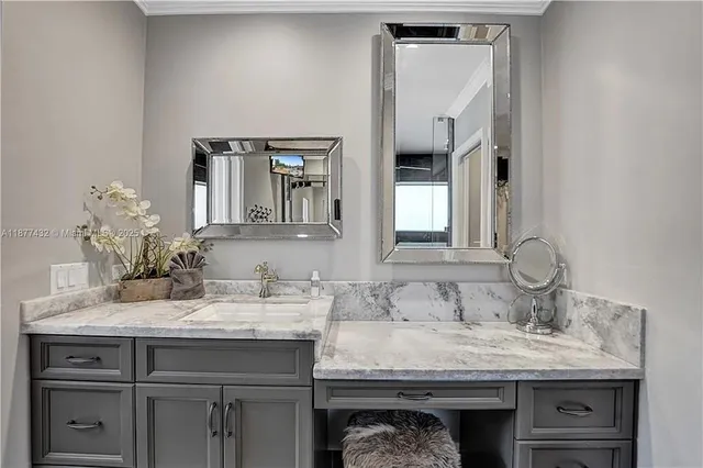 a bathroom with a granite countertop sink and a mirror