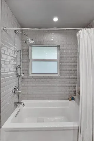 a bathroom with a shower and a bath tub