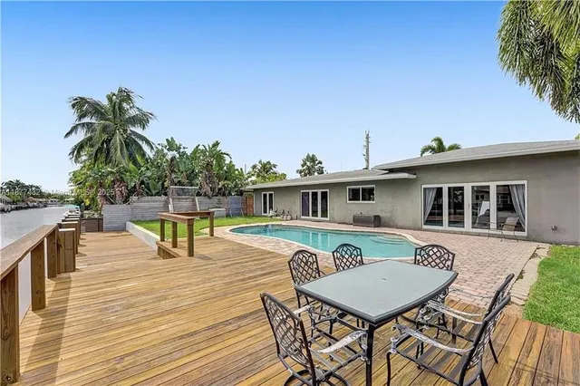 a swimming pool with outdoor seating and wooden fence