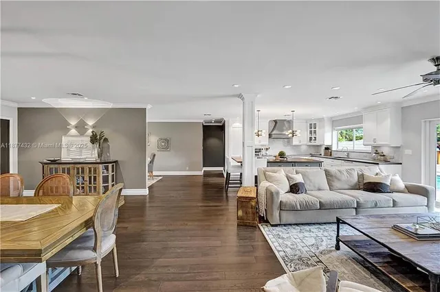 a living room with furniture and a dining table with wooden floor