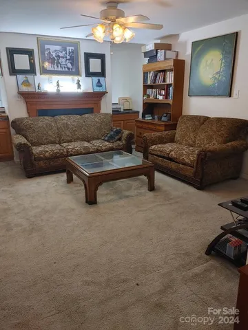 a living room with furniture and a air conditioner vent