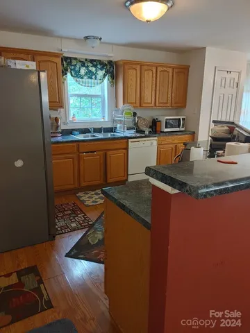 a kitchen with granite countertop a stove a sink and a wooden cabinets