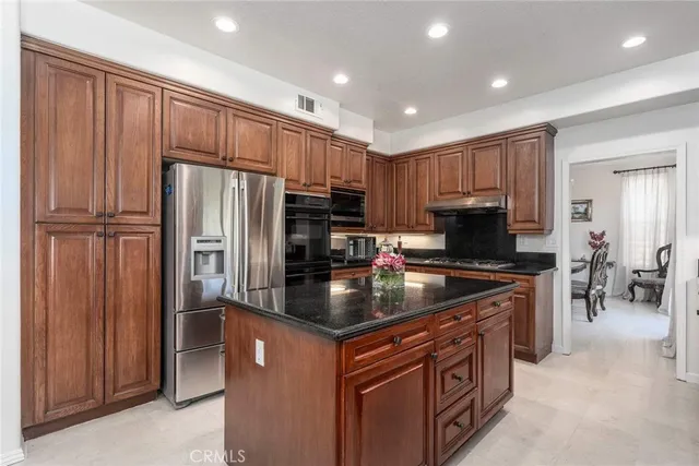 a kitchen with stainless steel appliances granite countertop a refrigerator stove and sink
