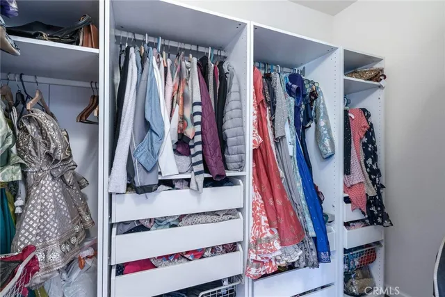 a view of walk in closet with clothes