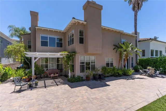 a view of a patio with plants and table and chairs under an umbrella