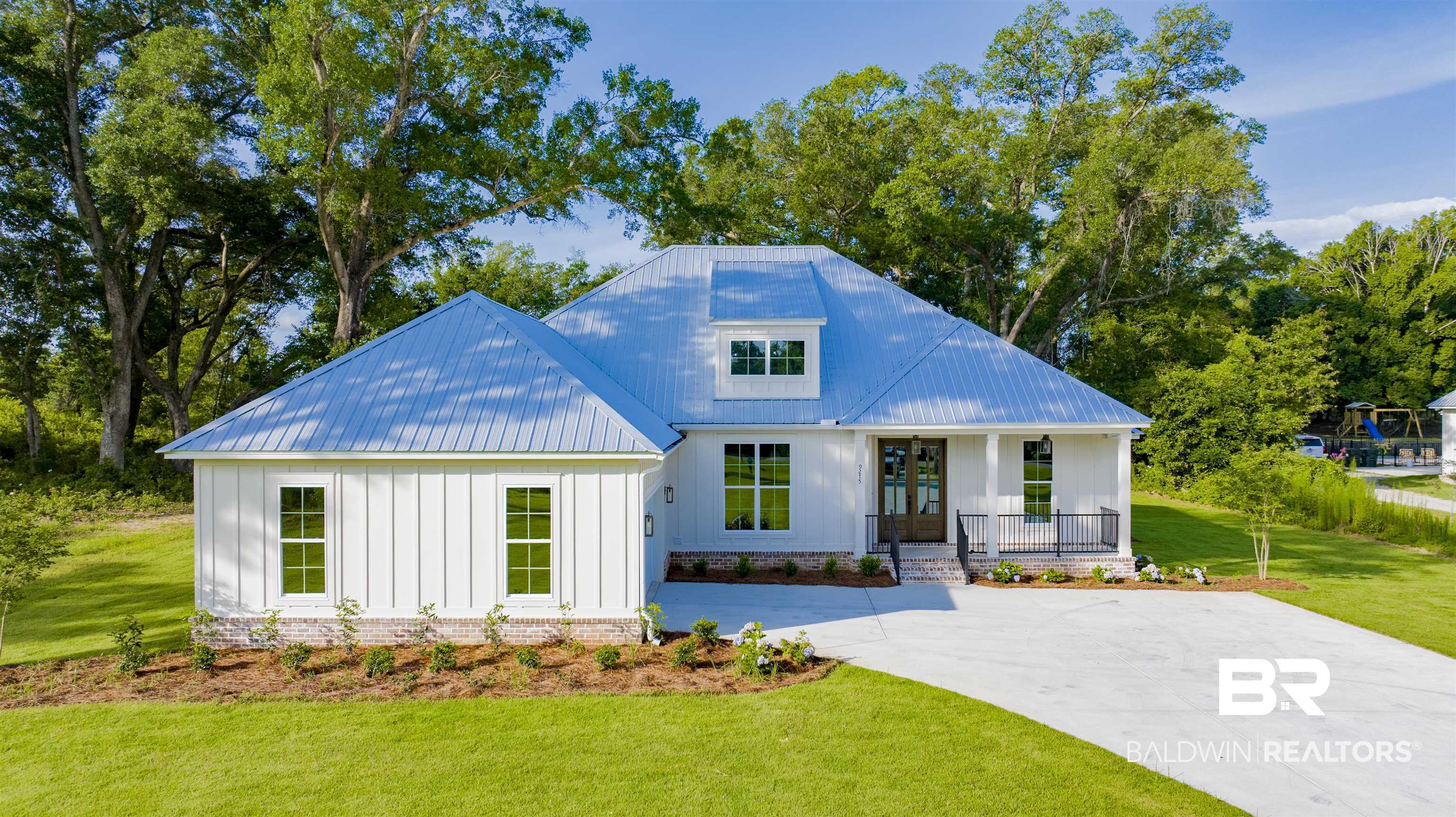 9275 Clarke Ridge Road Foley, AL 36535 - Photo 1 of 43 Modern farmhouse style home with board and batten siding, a porch, a front yard, concrete driveway, and a metal roof