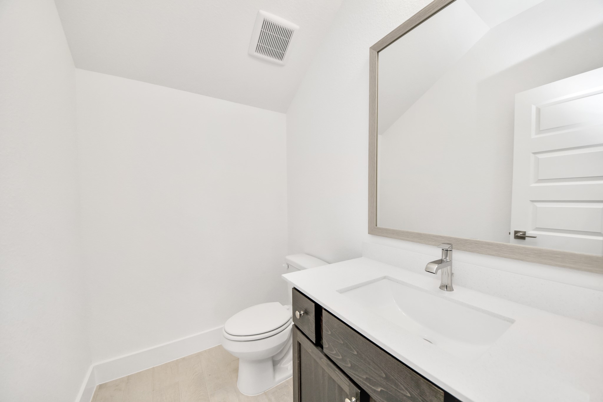 3106 Native Spg Drive Spring, TX 77373 - Photo 8 of 47 Sophisticated half bathroom adorned with contemporary finishes. The elegant 5-panel door welcomes you to a space where style meets functionality. Notice the sleek hardware accents that add a touch of modern charm. The vanity boasts light-colored countertops, beautifully complemented by a tasteful vanity light, creating a well-lit and inviting atmosphere.