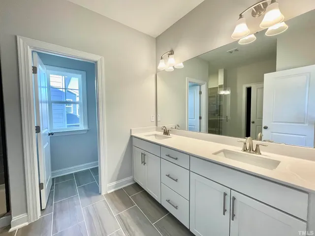 a bathroom with a double vanity sink and a mirror