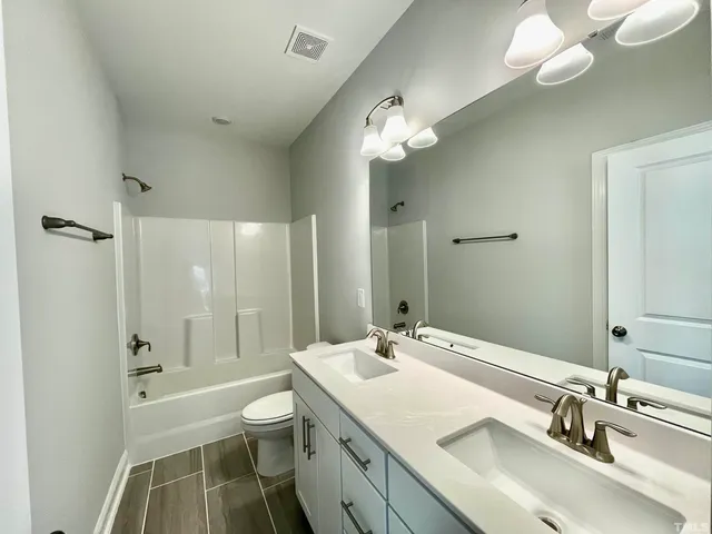 a bathroom with a sink a toilet and a large mirror