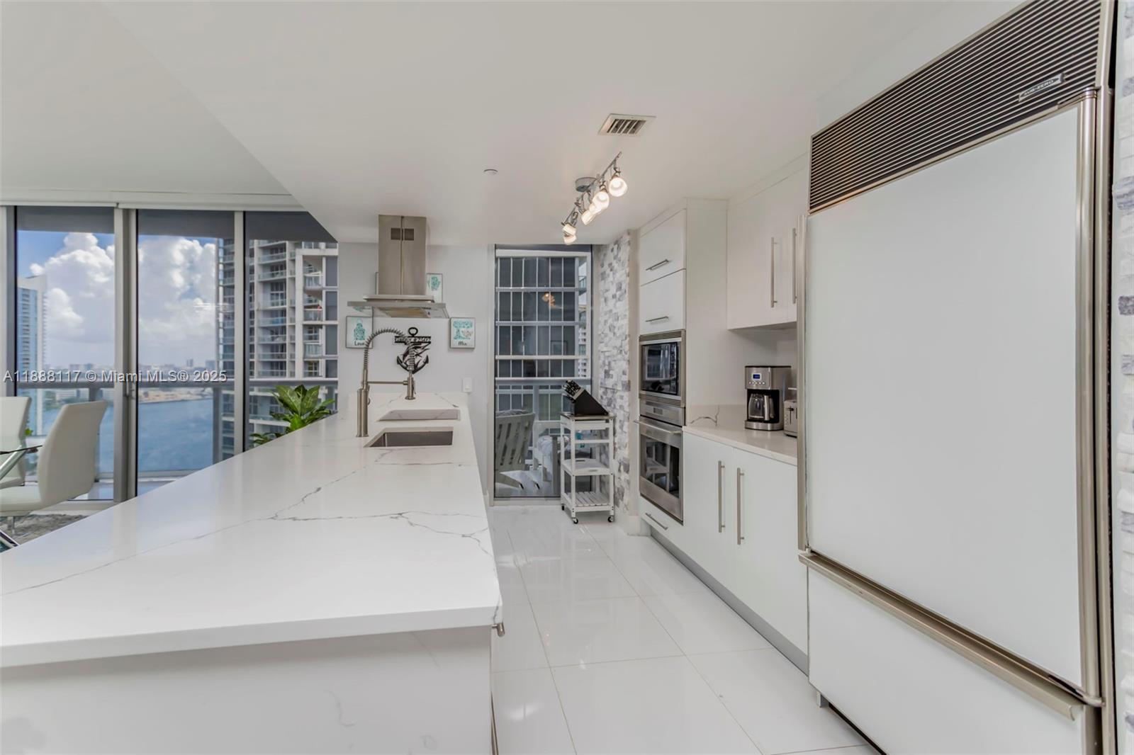 485 Brickell Avenue, Unit 2502 Miami, FL 33131 - Photo 6 of 24 a kitchen with white cabinets and white appliances