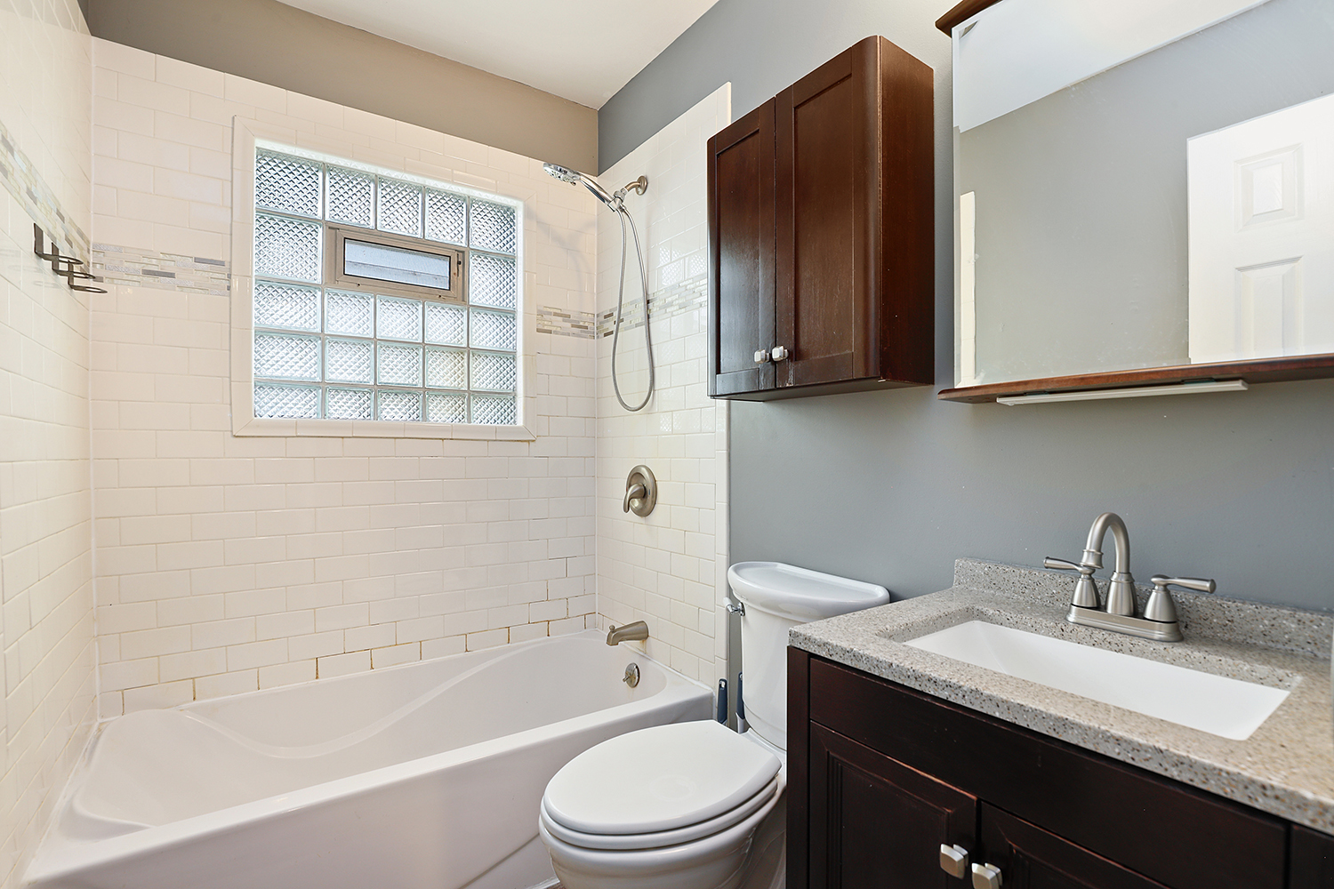 231 West 35th Street Steger, IL 60475 - Photo 12 of 17 a bathroom with a granite countertop sink toilet a mirror and bathtub
