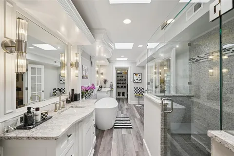 a large spacious bathroom with a granite countertop sink mirror and a bathtub