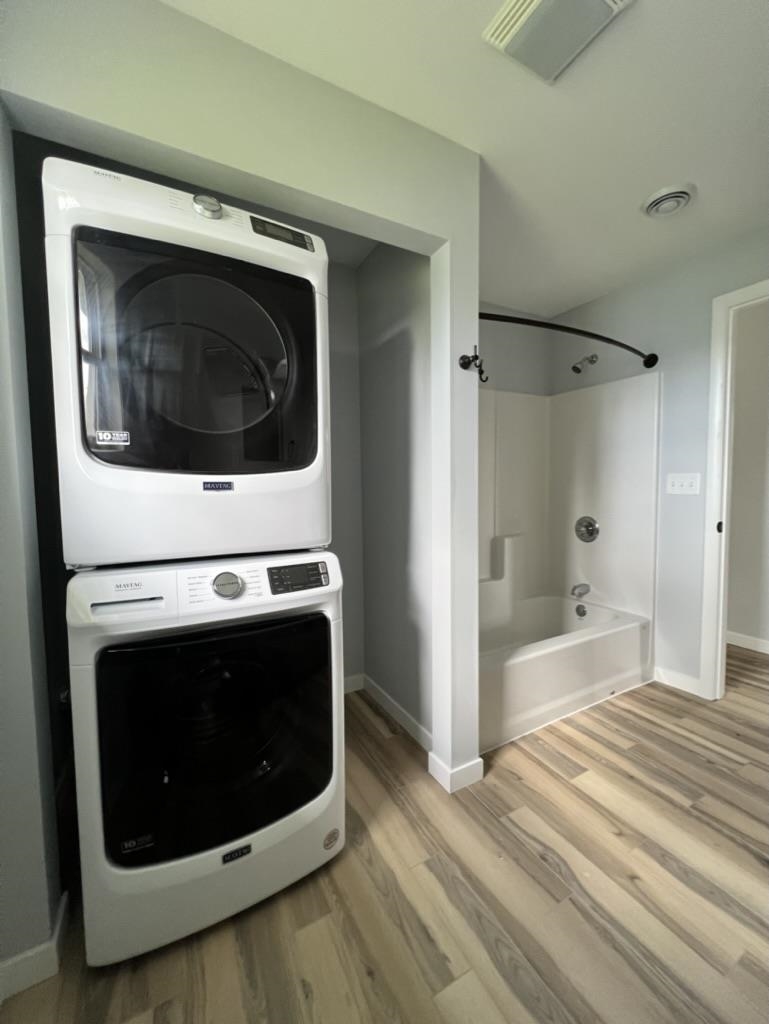 35 Field Road Silver Bay, MN 55614 - Photo 12 of 20 Full bath with shower / bathtub combination, light wood-style floors, and stacked washer and clothes dryer
