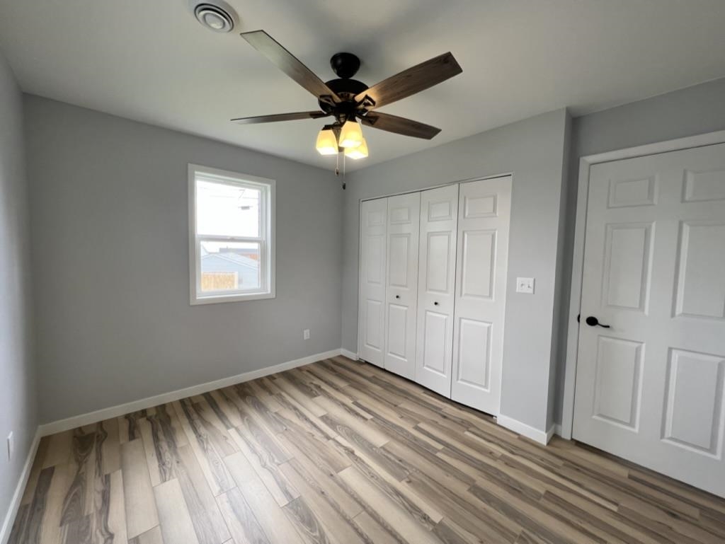 35 Field Road Silver Bay, MN 55614 - Photo 14 of 20 Unfurnished bedroom featuring light wood-style flooring, a ceiling fan, and a closet