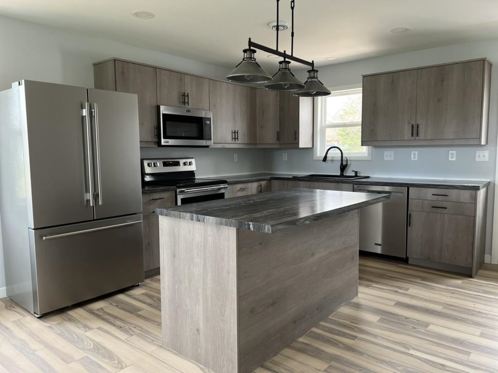 35 Field Road Silver Bay, MN 55614 - Photo 5 of 20 Kitchen with stainless steel appliances, a kitchen island, decorative light fixtures, and light wood-type flooring