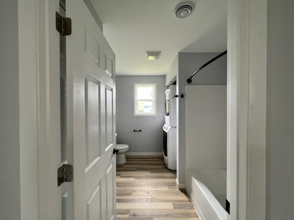 35 Field Road Silver Bay, MN 55614 - Photo 9 of 20 Bathroom featuring shower / washtub combination, light wood-style flooring, and stacked washer and clothes dryer