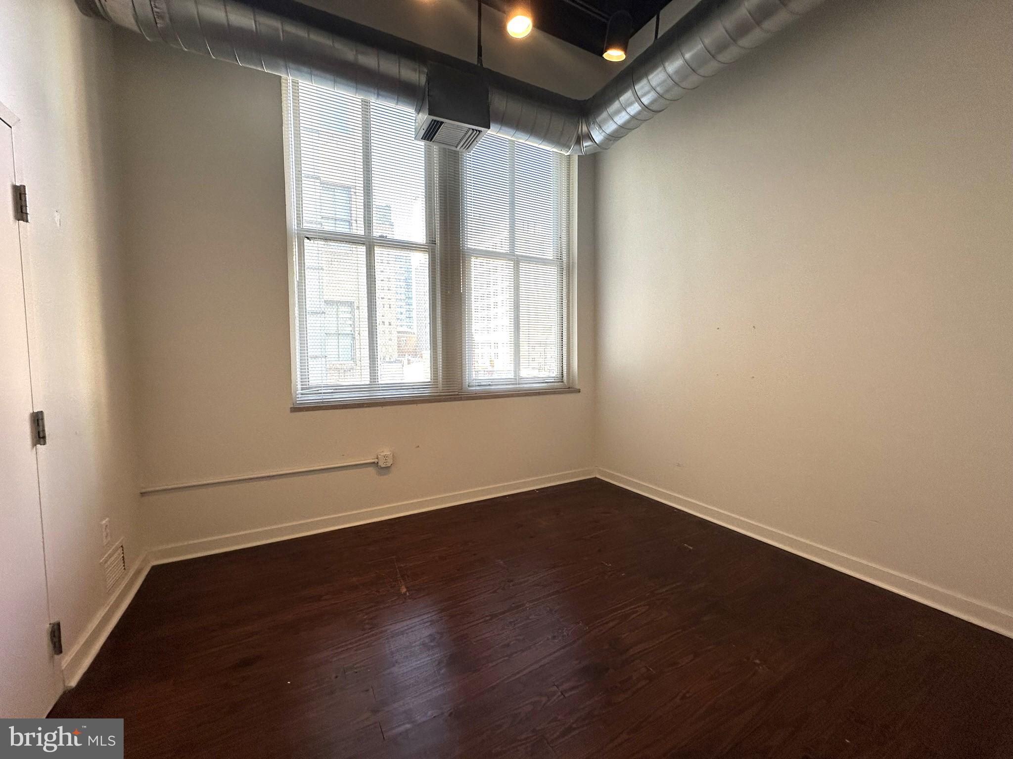 1510 Chestnut Street, Unit 902 Philadelphia, PA 19102 - Photo 14 of 19 an empty room with wooden floor and windows