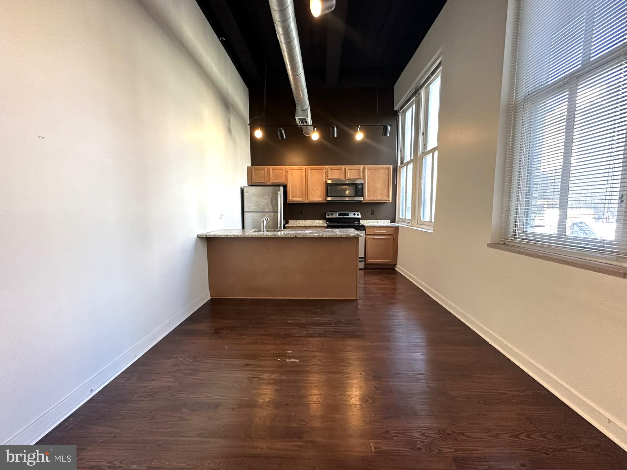 1510 Chestnut Street, Unit 902 Philadelphia, PA 19102 - Photo 2 of 19 a view of a kitchen with a sink wooden floor and a window