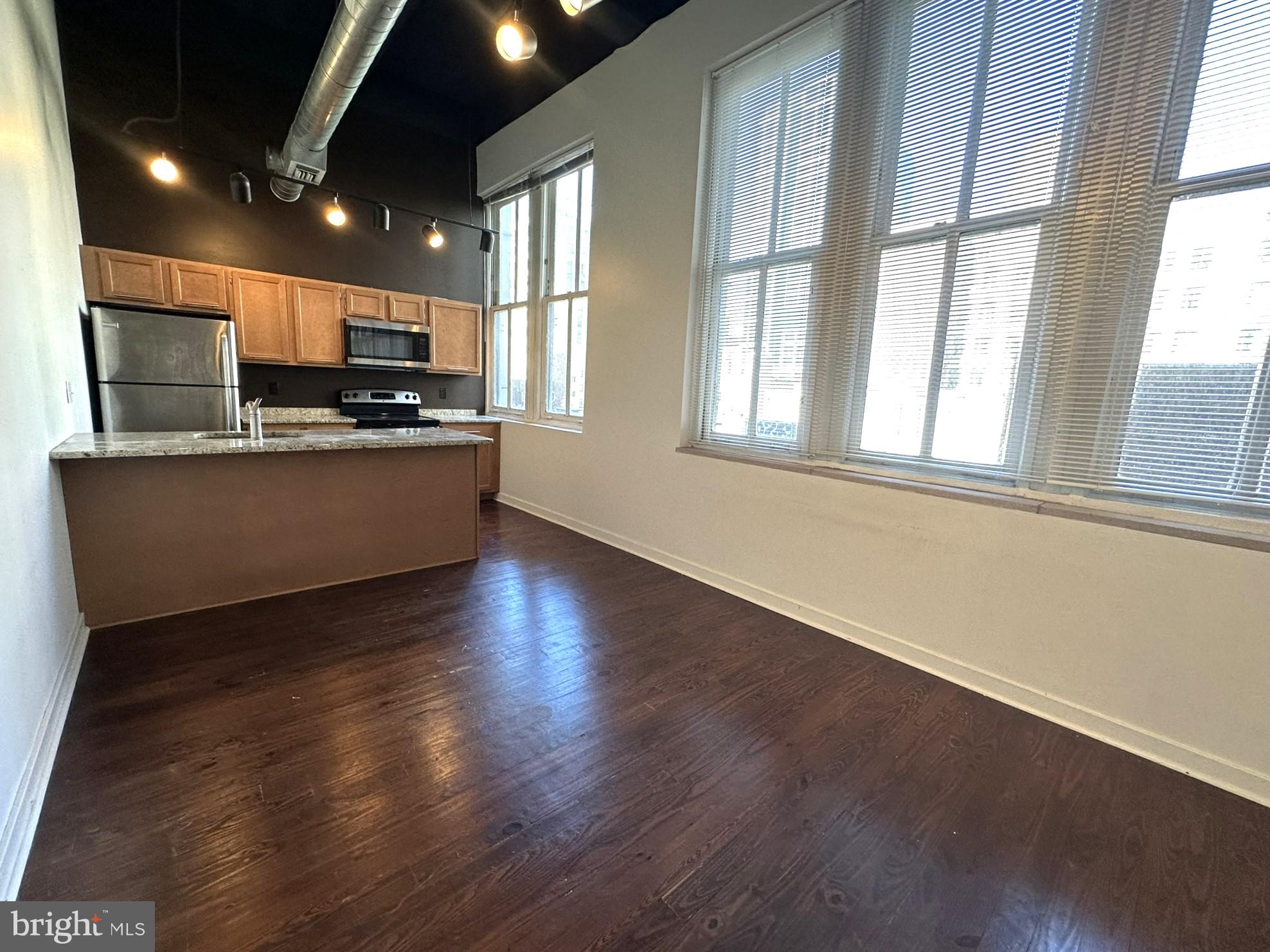 1510 Chestnut Street, Unit 902 Philadelphia, PA 19102 - Photo 3 of 19 a living room with stainless steel appliances kitchen island wooden floor and large window