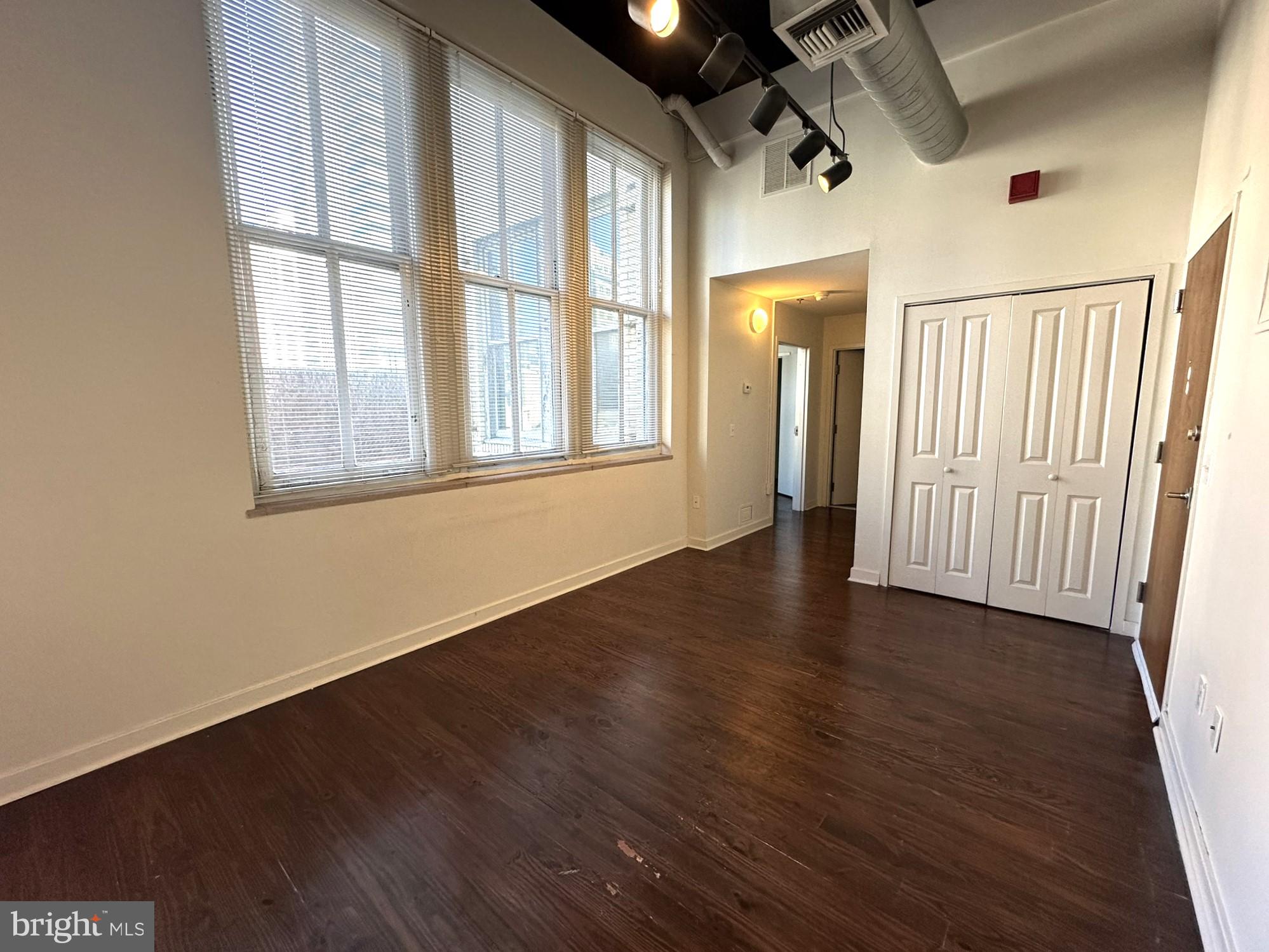 1510 Chestnut Street, Unit 902 Philadelphia, PA 19102 - Photo 4 of 19 an empty room with wooden floor and windows