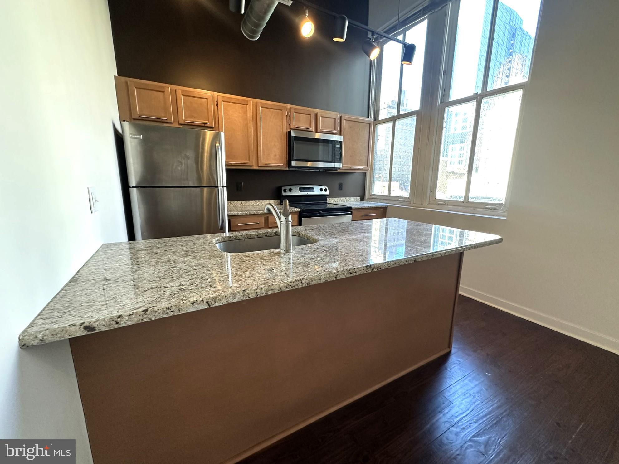 1510 Chestnut Street, Unit 902 Philadelphia, PA 19102 - Photo 8 of 19 a kitchen with stainless steel appliances granite countertop a refrigerator a sink dishwasher a stove and a microwave oven on granite countertops
