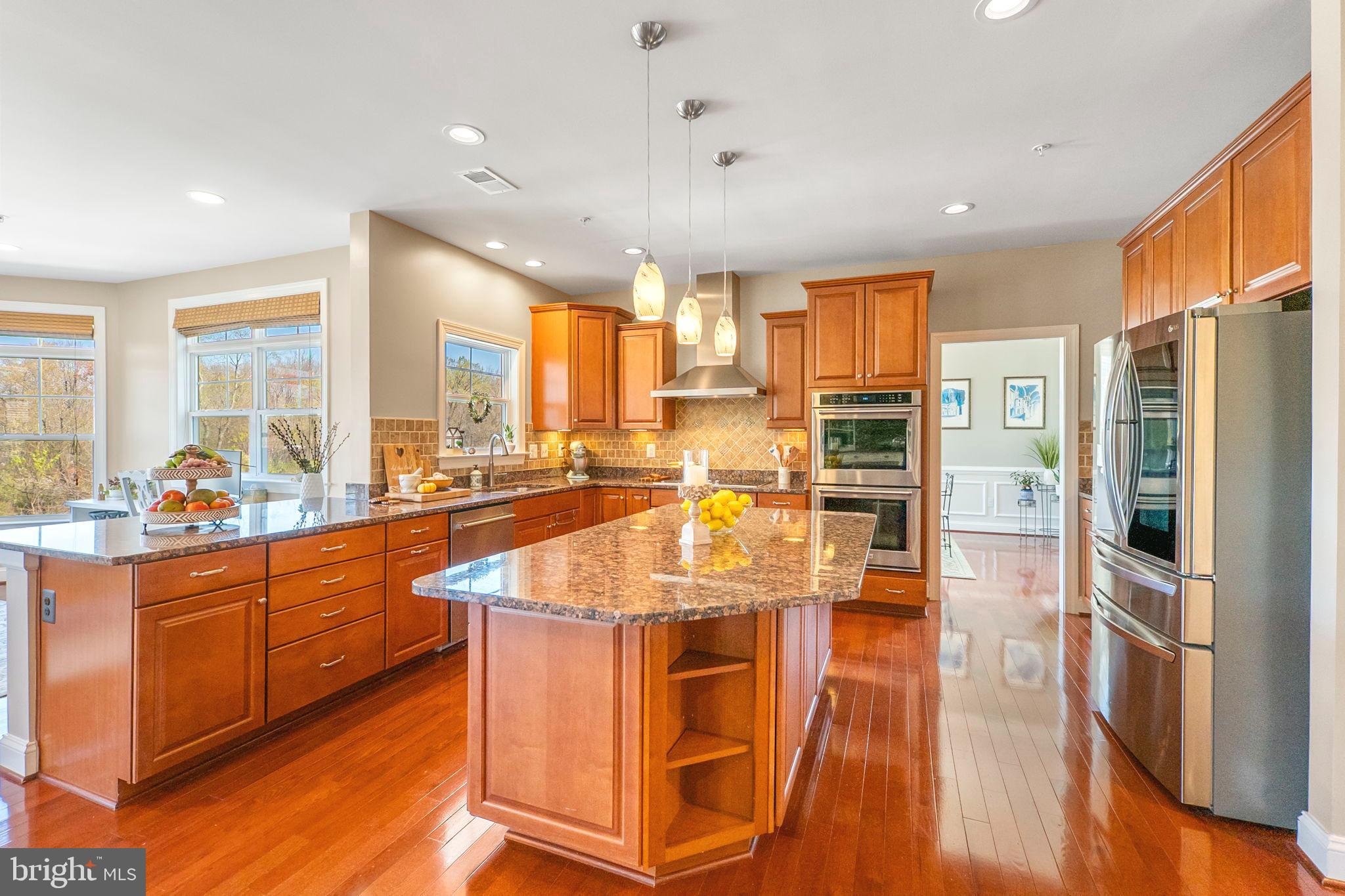 18004 Bliss Drive Poolesville, MD 20837 - Photo 16 of 57 a kitchen with stainless steel appliances granite countertop a refrigerator a stove and a wooden floors