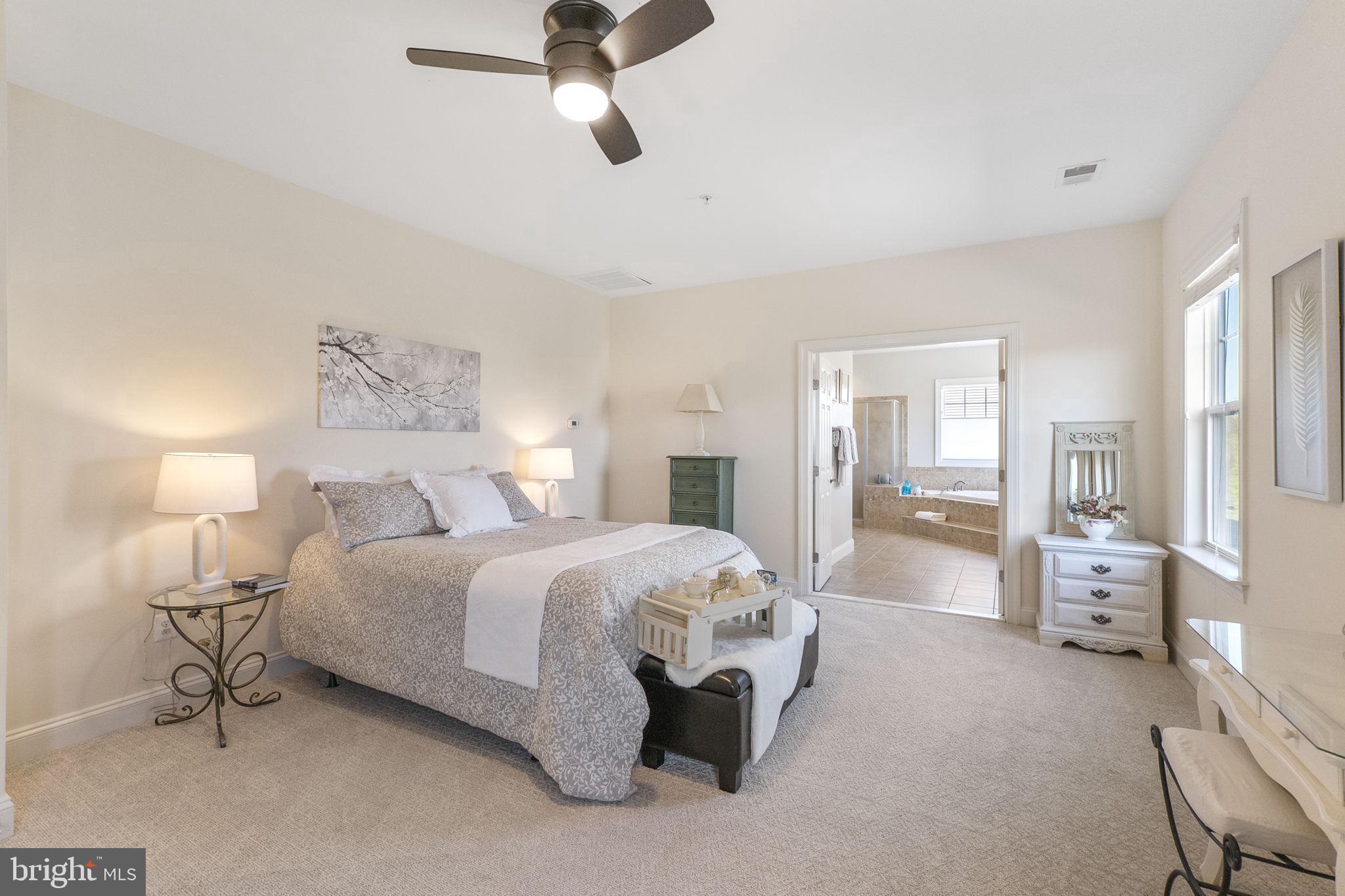 18004 Bliss Drive Poolesville, MD 20837 - Photo 20 of 57 a spacious bedroom with a bed and a chandelier