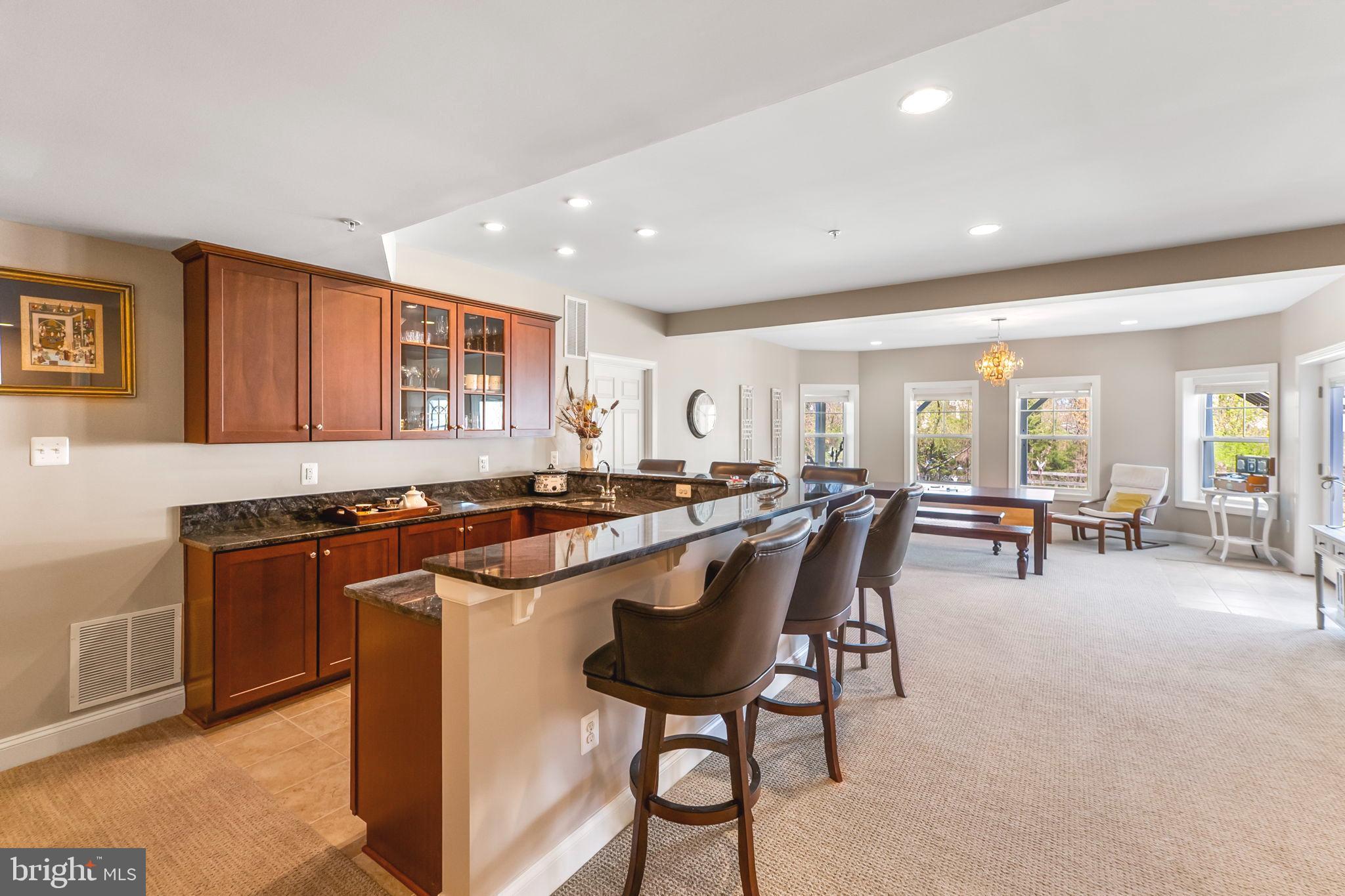 18004 Bliss Drive Poolesville, MD 20837 - Photo 39 of 57 a kitchen with stainless steel appliances granite countertop a stove a sink a refrigerator and chairs