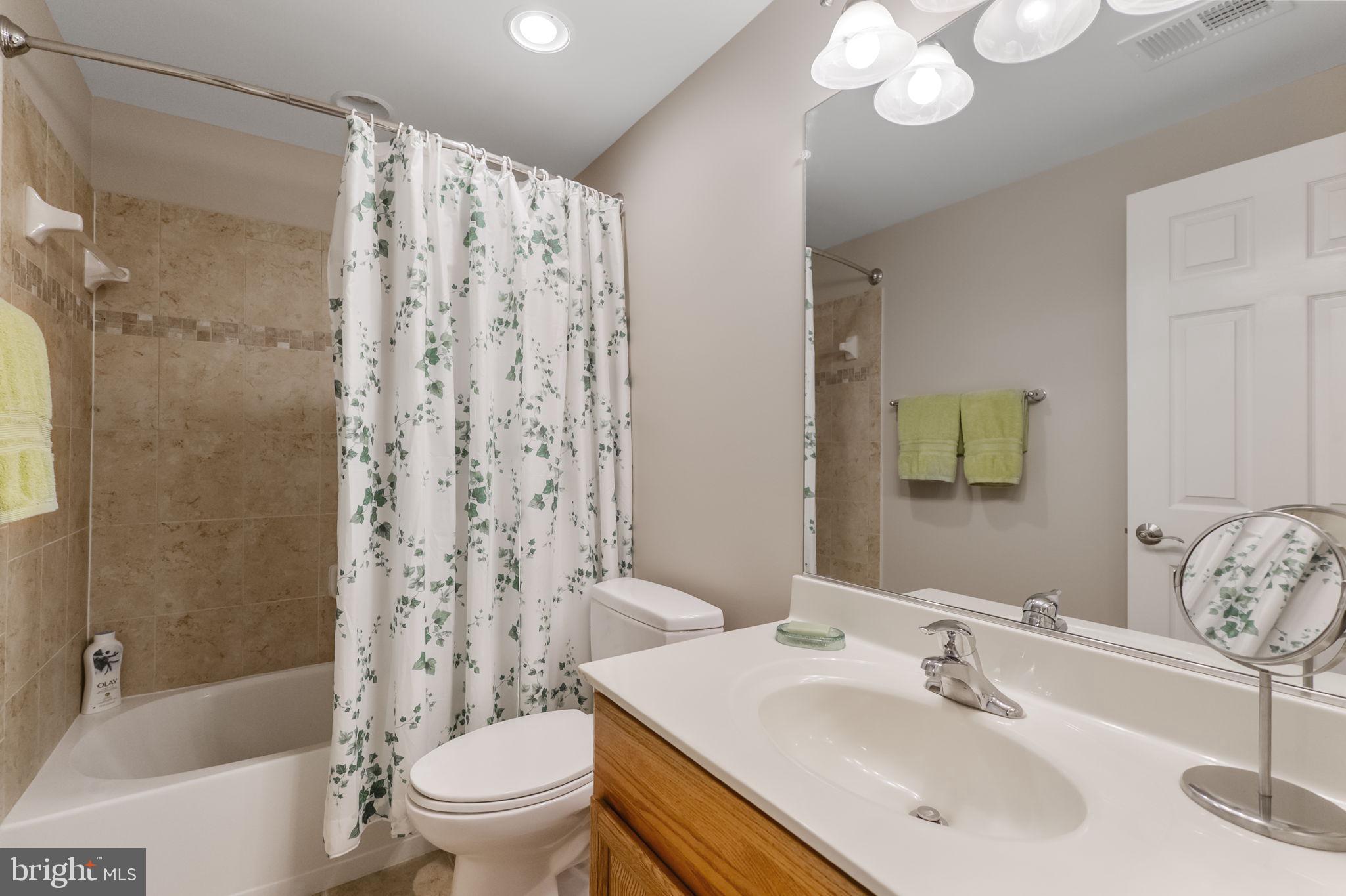 18004 Bliss Drive Poolesville, MD 20837 - Photo 41 of 57 a bathroom with a sink a toilet a mirror a bathtub and shower