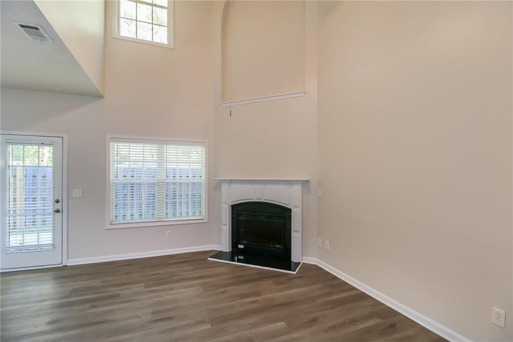 3824 Augustine Place Rex, GA 30273 - Photo 4 of 24 an empty room with wooden floor fireplace and windows