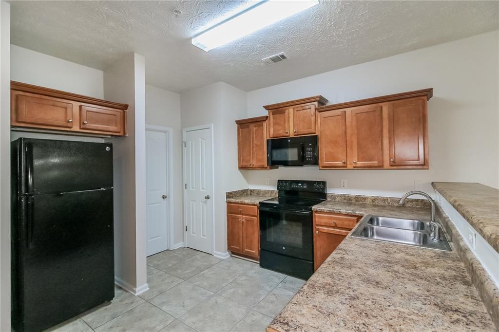 3824 Augustine Place Rex, GA 30273 - Photo 7 of 24 a kitchen with stainless steel appliances granite countertop a refrigerator stove and sink