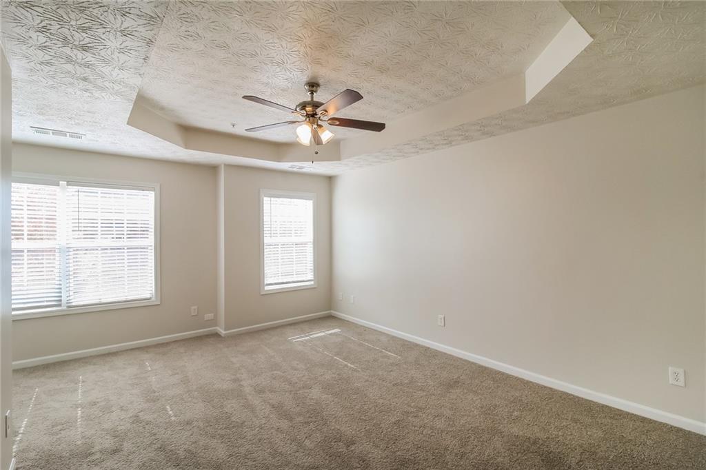3824 Augustine Place Rex, GA 30273 - Photo 10 of 24 an empty room with chandelier fan and windows