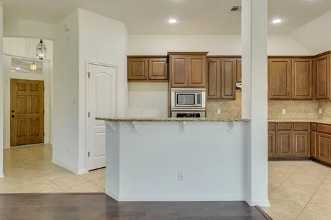 a kitchen with stainless steel appliances granite countertop a refrigerator and a stove top oven