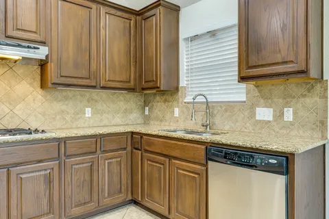 a kitchen with stainless steel appliances granite countertop a sink and dishwasher cabinets with wooden floor