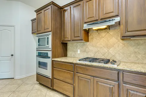 a kitchen with stainless steel appliances granite countertop a sink stove and cabinets