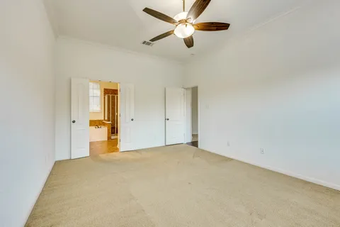 an empty room with closet and a ceiling fan