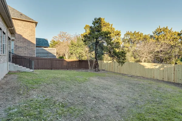 a view of a backyard with wooden fence