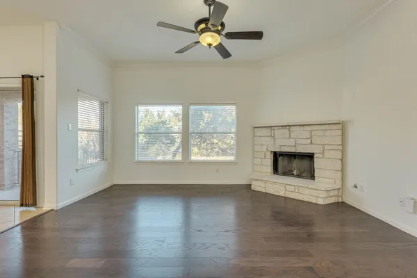 wooden floor fireplace and windows in an empty room