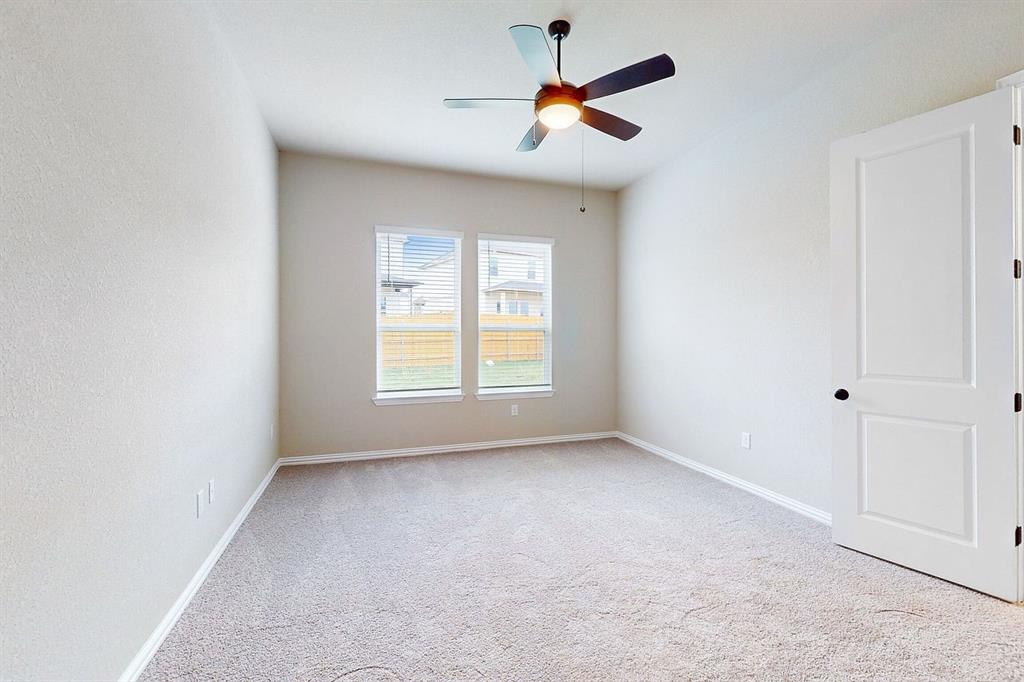 4907 Escape Rivera Drive Austin, TX 78747 - Photo 7 of 28 An airy bedroom with dual windows offers a neutral canvas for personalization.
