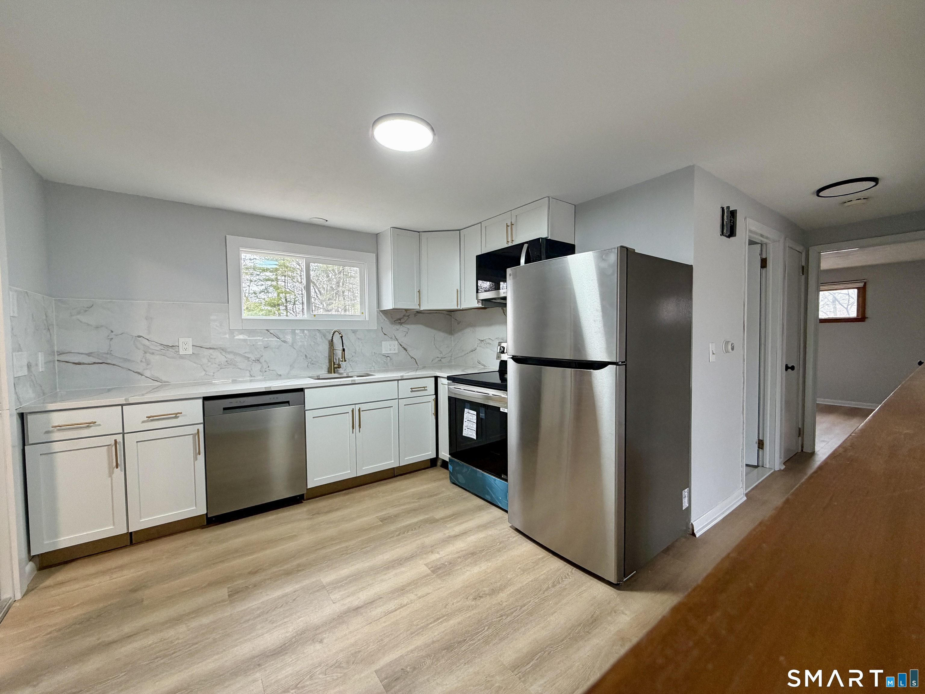 164 Sycamore Street, Unit 2R Bristol, CT 06010 - Photo 4 of 11 a kitchen with a refrigerator sink and cabinets