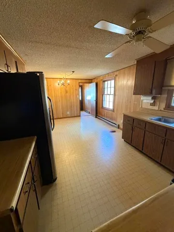 a view of a kitchen with a sink and a refrigerator
