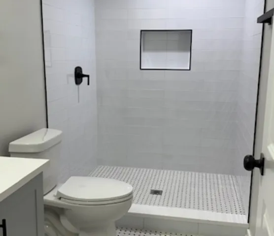 a white toilet sitting next to a bathroom sink