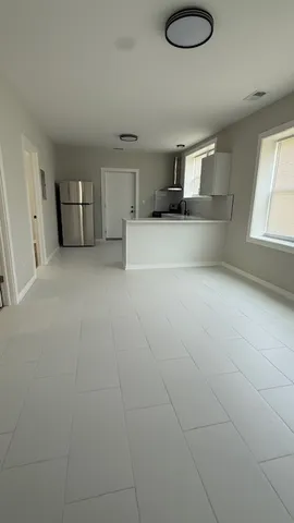 a view of kitchen and windows with white cabinets